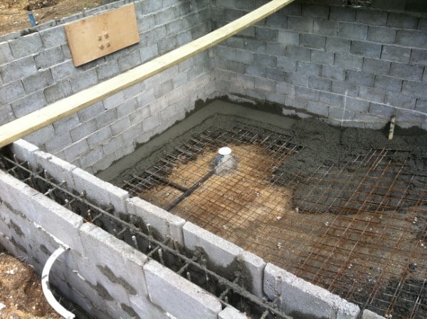 A concrete block structure with steel reinforcement and wet cement in the base.
